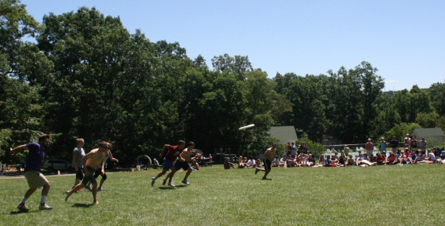 Staff v World frisbee game. World team throws off.